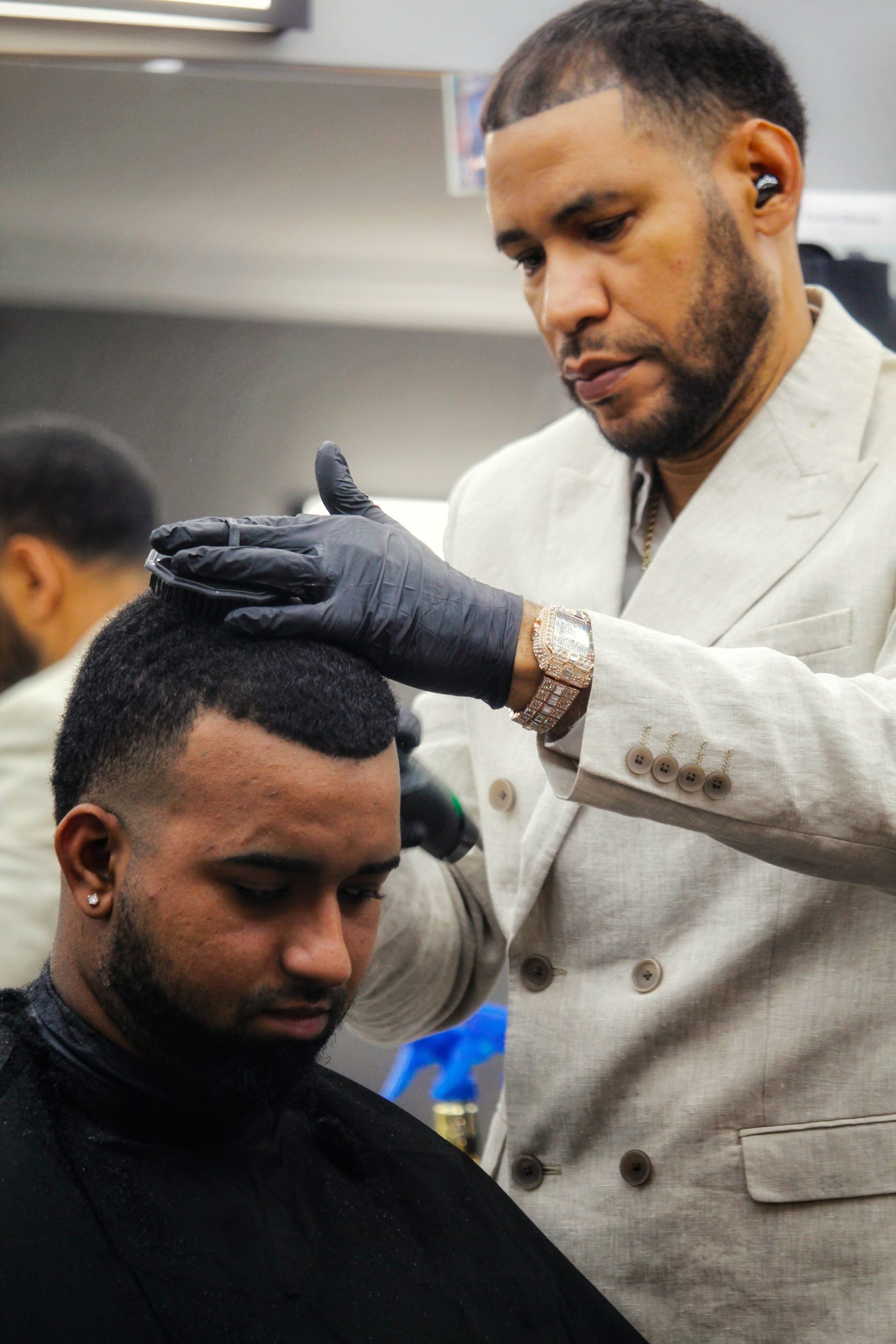 Barber styling a client's hair in a stylish modern salon. Professional grooming service.